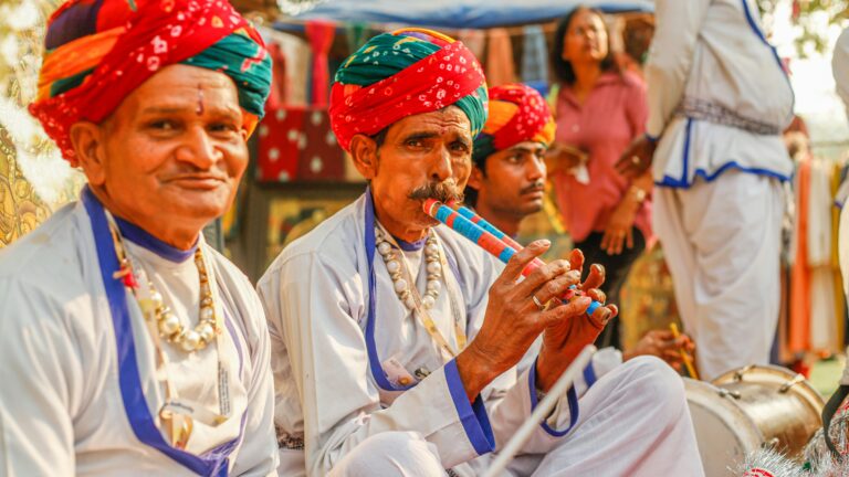 Colorful Rajasthani musicians playing traditional instruments outdoors, showcasing cultural heritage.