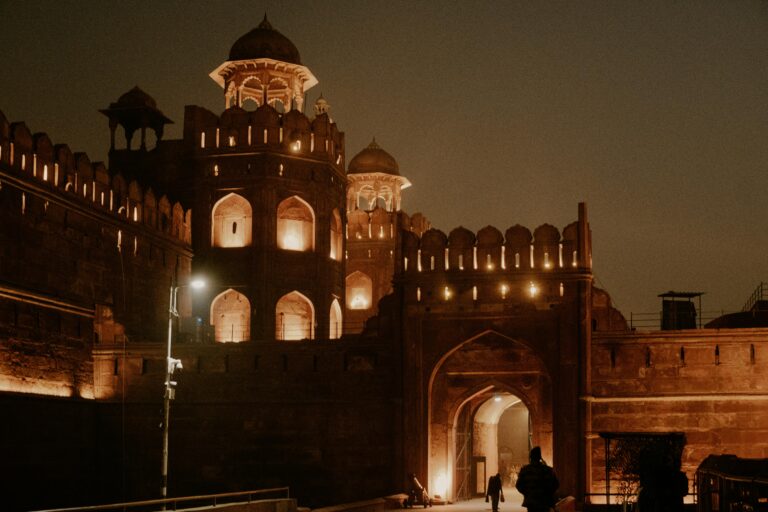 The Red Fort in New Delhi illuminated at night, showcasing its historic architectural beauty.