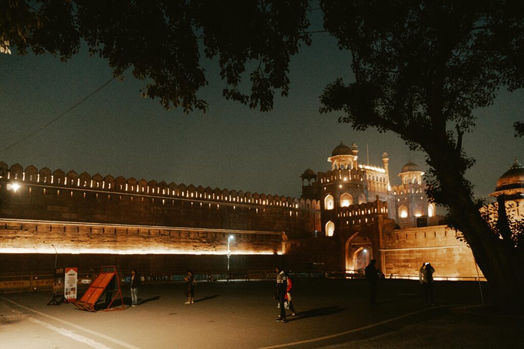 Illuminated view of the historic Red Fort in New Delhi at night, highlighting its architectural beauty.